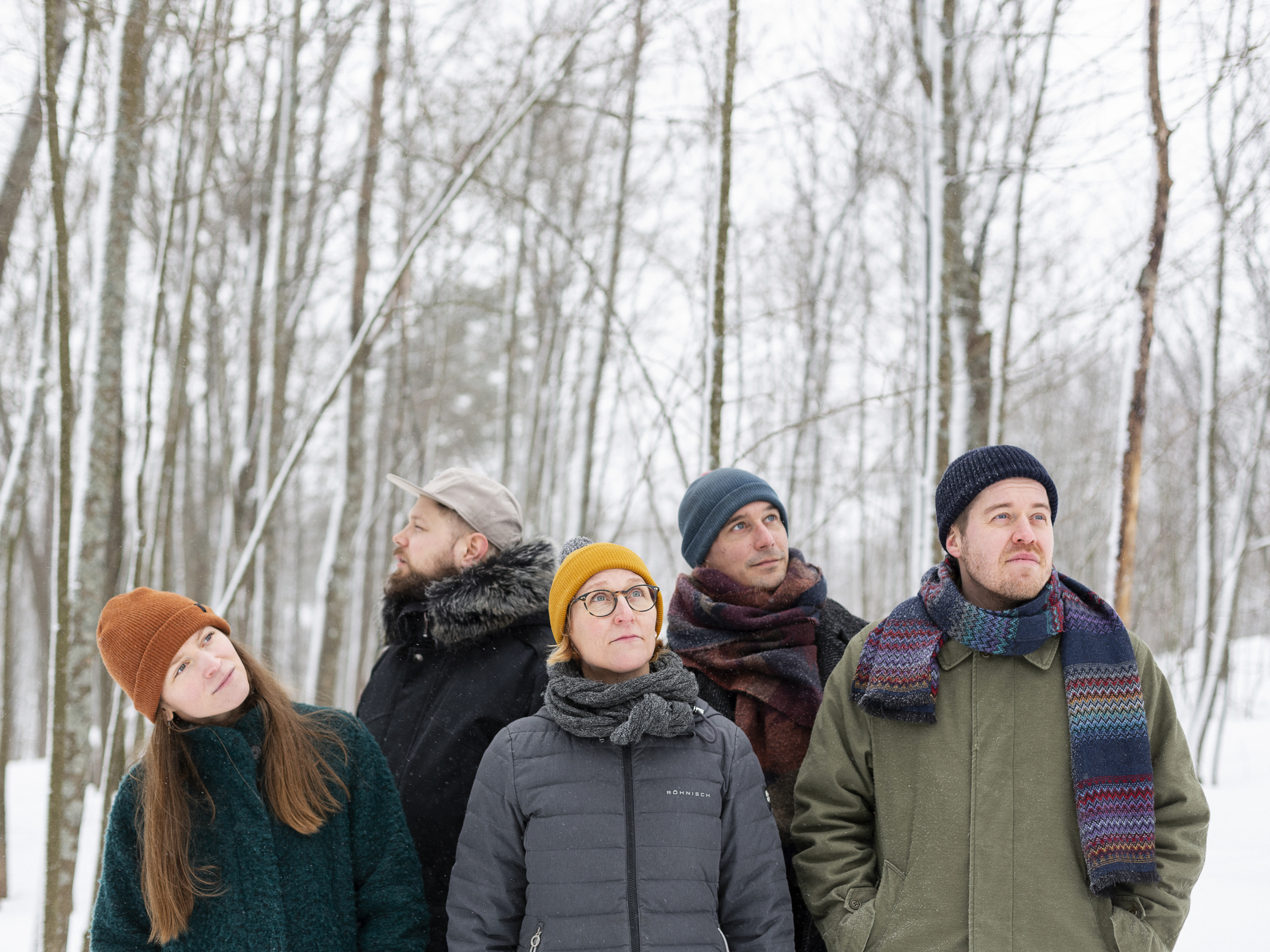 Tutkijat seisovat lumisessa metsässä.