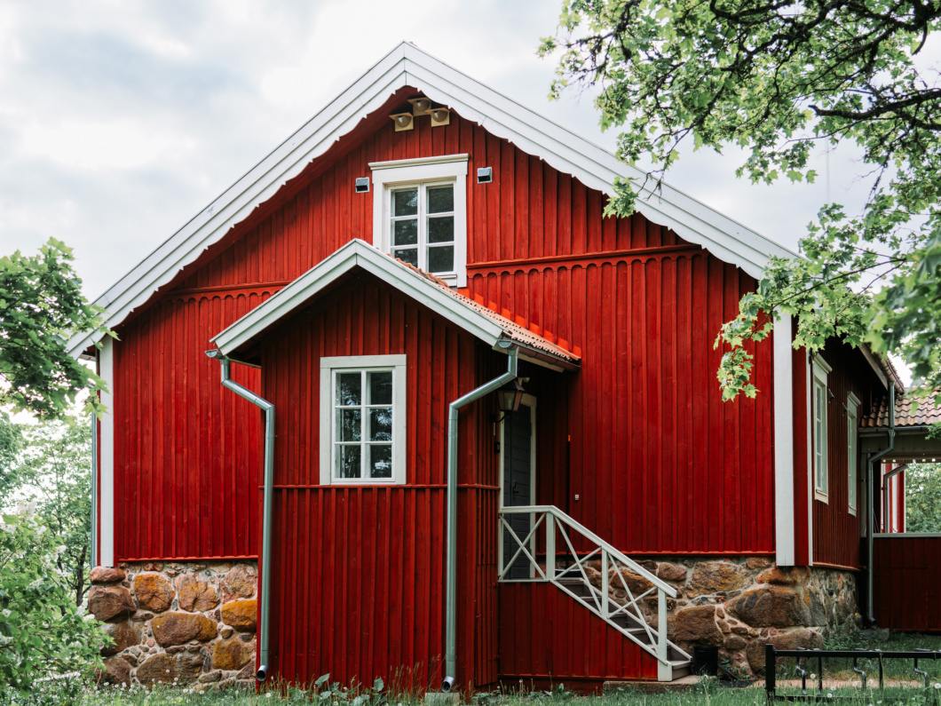 Punaisen rakennuksen räystään alle asennetteja pääskyjen tekopesiä.